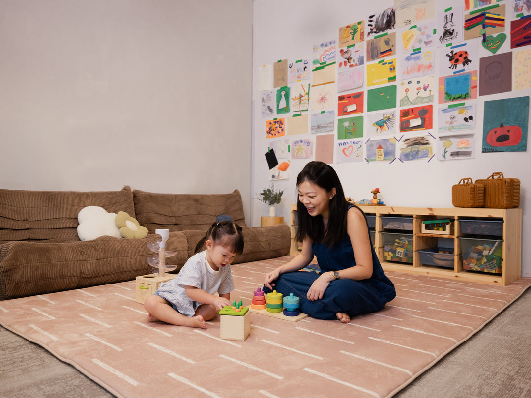 A woman and a young child sitting together and playing on the Lollibly Shortbread Plush Playmat in a cosy, well-lit playroom.