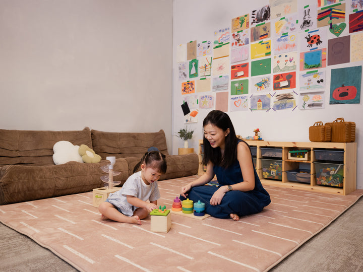 A woman and a young child sitting together and playing on the Lollibly Shortbread Plush Playmat in a cosy, well-lit playroom.
